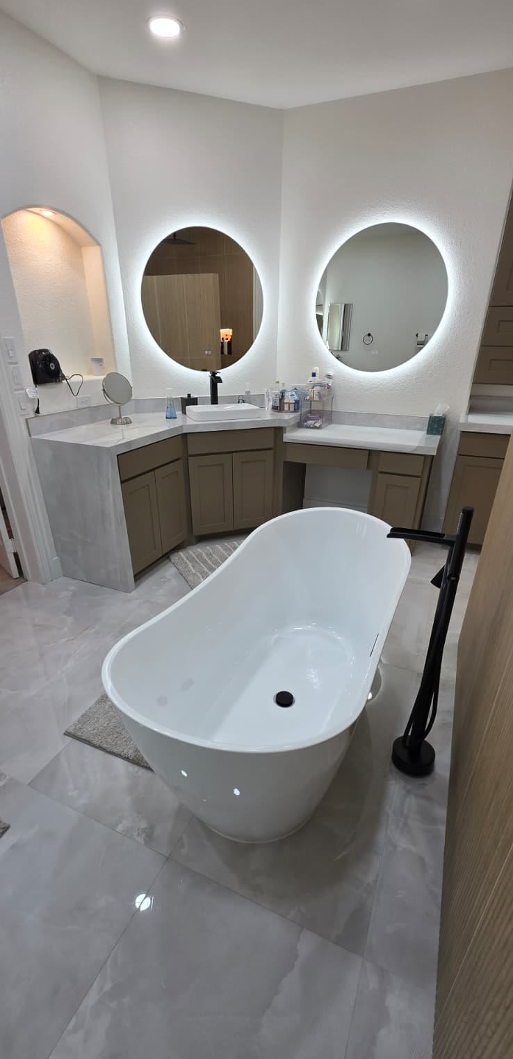 Freestanding soaking tub and matte black filler in a finished DFW bathroom