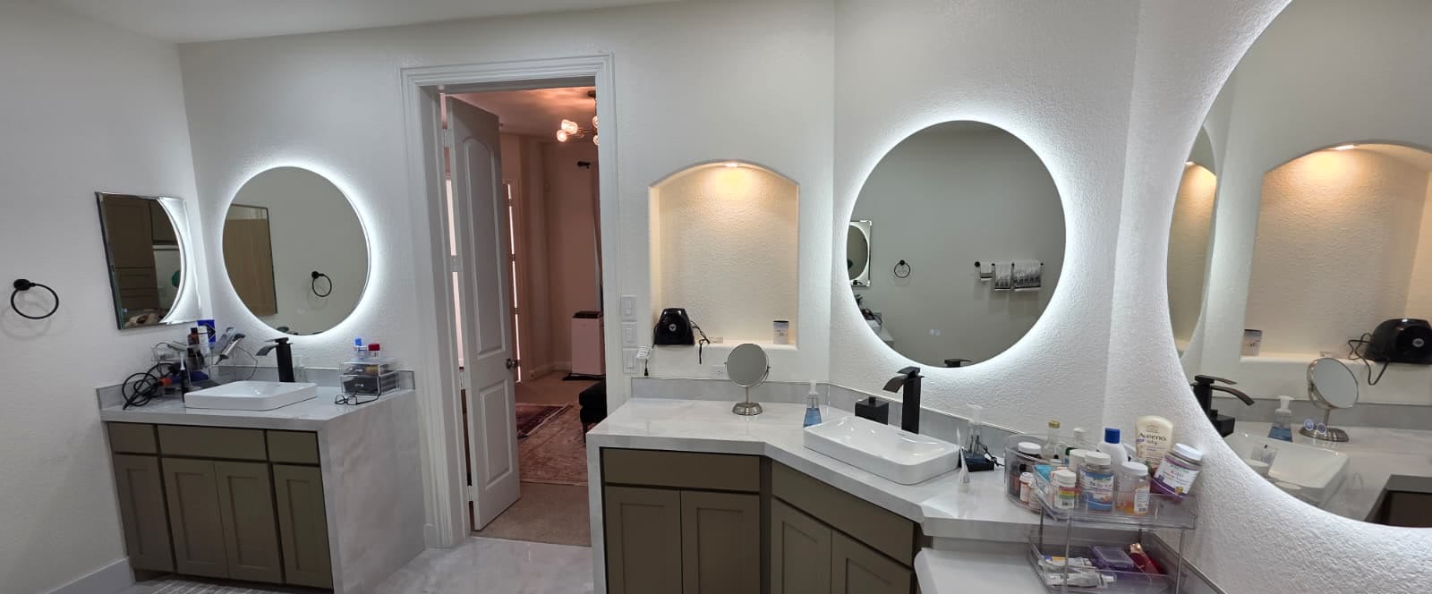 Finished primary bathroom with double vanities and backlit mirrors